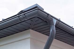 Roof corner showing new gutter and downpipe installation